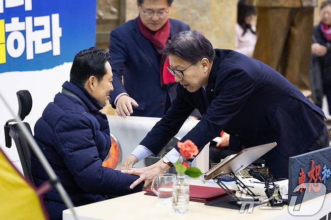 지난 19일 서울 여의도 국회 로텐더홀에 마련된 장동혁 국민의힘 대표 단식 농성장을 찾은 박형준 부산시장이 배웅을 위해 일어서려는 장 대표를 만류하고 있다. 2026.1.19/뉴스1 ⓒ News1 유승관 기자