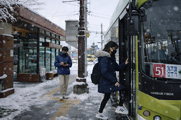 눈 내리는 날 경주 황성공원·시립도서관 버스정류장에서 청소년들이 시내버스에 탑승하고 있다. [사진=경주시청]
