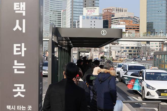 Commuters wait for cabs at a taxi stand in front of Seoul Station on Jan. 14. (Yonhap)