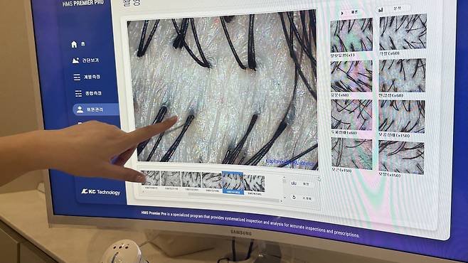 A scalp specialist explains a customer’s scalp condition during a 10-minute consultation at the scalp specialty store Moclock in Gangnam District, western Seoul, Jan. 14. [WOO JI-WON]