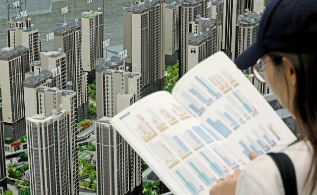 서울 서초구에서 개관한 한 아파트 견본주택을 찾은 예비 청약자들이 아파트 단지 모형을 살펴보고 있다. 뉴스1