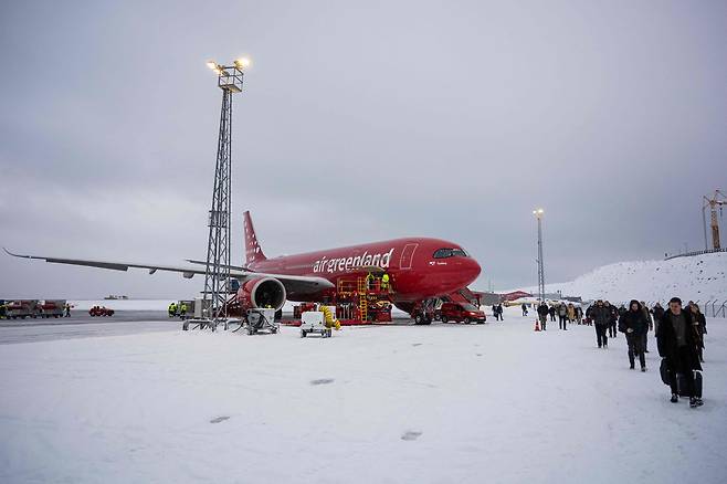 19일 덴마크 코펜하겐을 출발한 에어그린란드 여객기를 타고 그린란드 수도 누크 공항에 내린 승객들이 눈 덮인 길을 걸어 도착 터미널로 이동하고 있다. ‘북극의 오지’로 여겨졌던 그린란드가 최근 미국이 주도하는 세계 질서 재편의 최전선으로 떠오르면서 누크행 항공기의 편수와 승객도 크게 늘었다. 20일 본지 특파원이 누크로 향하는 길에서 만난 덴마크·그린란드인들은 노골적으로 그린란드를 탐내는 미국에 입을 모아 우려를 표했다./AFP 연합뉴스