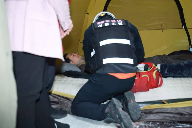 21일 국회 로텐더홀 단식 농성장에서 구급대원이 통일교·공천헌금 '쌍특검' 수용을 요구하며 이레째 단식 중인 국민의힘 장동혁 대표의 바이탈을 체크하고 있다. /연합뉴스