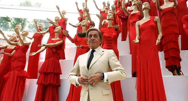 패션 디자이너 발렌티노 가라바니가 2007년 7월 6일 이탈리아 로마 아라 파치스 박물관에서 열린 발렌티노 45주년 기념 패션쇼에서 자신이 디자인한 붉은색 드레스들 앞에서 기념 촬영을 하고 있다. 로마=AP 뉴시스