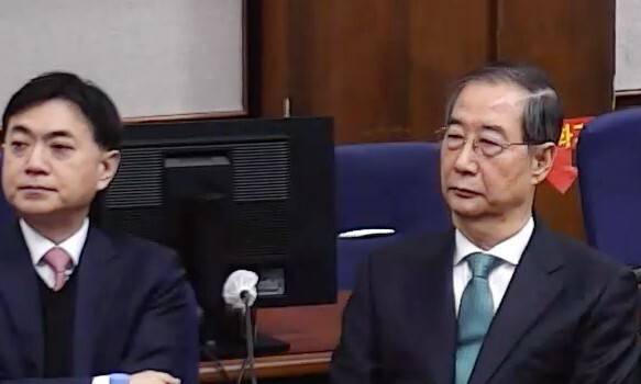 내란 중요임무 종사 혐의를 받는 한덕수 전 국무총리(왼쪽)가 21일 서울중앙지법에서 열린 1심 선고 공판에 출석해 있다. 서울중앙지법 제공