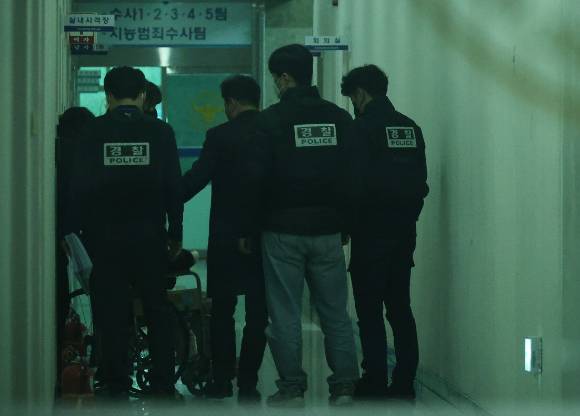 지난해 3월 7일 대전서부경찰서에서 첫 대면조사를 마친 대전 초등생 살해 교사 명재완이 조사실을 나오고 있다. 경찰들이 그를 유치장에 입감하기 위해 이동시키고 있다. [사진=연합뉴스]