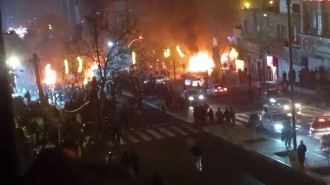 지난 14일(현지시간) 이란 테헤란의 사다트 아바드 광장에서 시위 중 차량에 불이 난 모습. AFP=연합뉴스