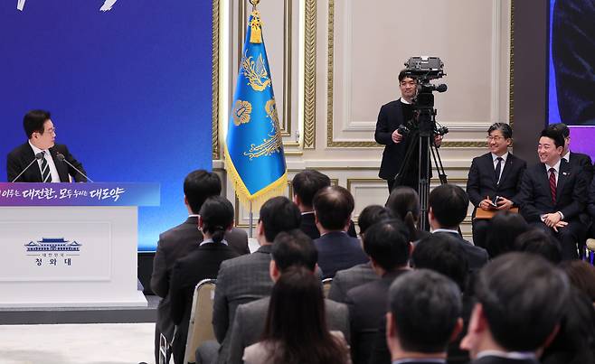 President Lee Jae Myung, far left, glances at his chief of staff, Kang Hoon-sik, after a reporter comments on their strong bond during a New Year’s press conference at the Blue House’s Yeongbingwan state guest house in central Seoul on Jan. 21. [JOINT PRESS CORPS]