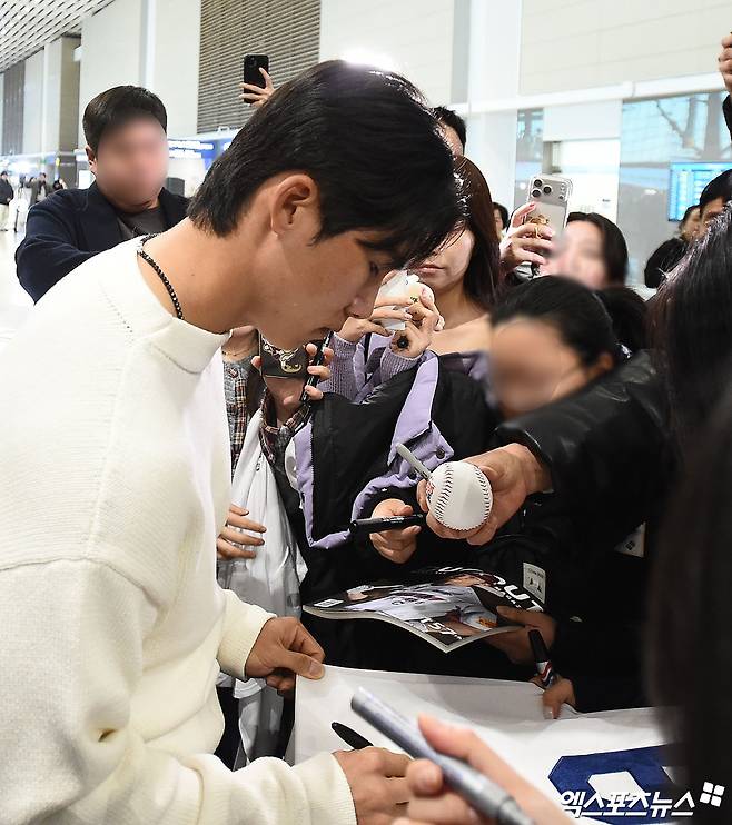 미국 프로야구 메이저리그(MLB) LA 다저스 김혜성이 21일 오후 인천국제공항을 통해 미국으로 출국했다.   김혜성이 출국장에서 팬들에게 사인을 해주고 있다. 인천공항, 박지영 기자