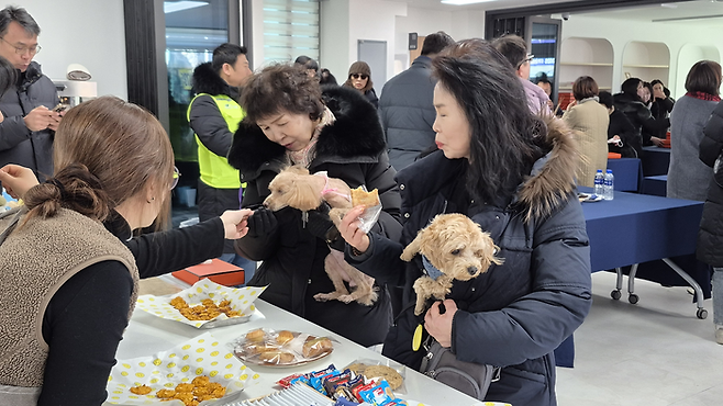 관음동물교육센터 개소식이 열린 22일 오후, 센터 1층 펫푸드 쿠킹실에서 반려견과 함께 방문한 주민들이 수제 간식을 받아보고 있다. 조윤화 기자