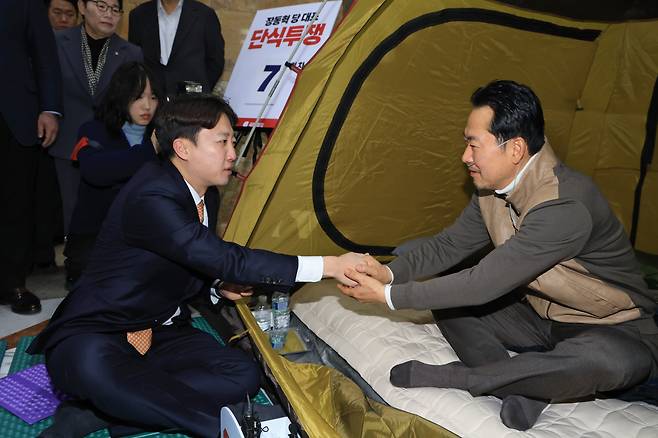 이준석 개혁신당 대표가 21일 오전 서울 여의도 국회 로텐더홀에서 단식농성 중인 장동혁 국민의힘 대표와 손을 잡고 있다. (사진=뉴시스)