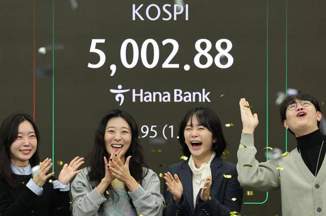 22일 오전 서울 중구 하나은행 딜링룸에서 딜러들이 코스피가 장중 5,000을 넘어서자 기뻐하고 있다. 연합뉴스