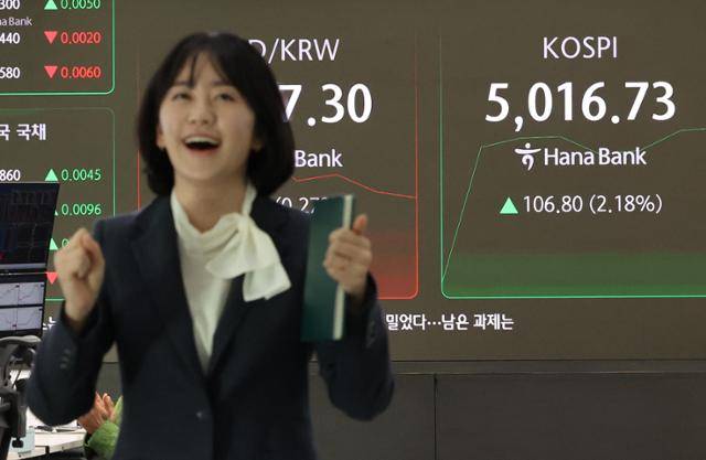 코스피지수가 장중 5,000을 넘어선 가운데 22일 서울 중구 하나은행 딜링룸에서 딜러가 환호하고 있다. 연합뉴스