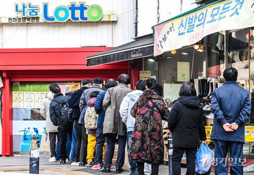 수원특례시 한 복권 판매점 앞에 로또를 사려는 손님들이 남녀노소 가리지 않고 길게 늘어서 있다. 경기일보DB