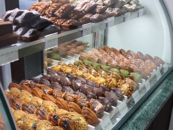 고소한 버터의 풍미와 다양한 재료 조합으로 사랑받는 구움 과자 맛집에 대한 관심이 커지고 있다. 사진은 과자방의 마들렌 쇼케이스. /사진=다이어리알