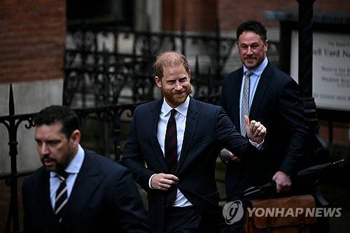21일 법원을 나서며 인사하는 해리 왕자 [AFP 연합뉴스 제공]