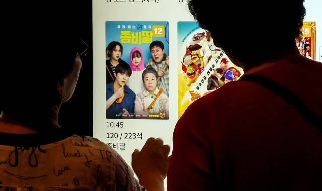 서울 시내 한 극장에서 관객들이 영화 시간표를 보고 있다. 뉴스1