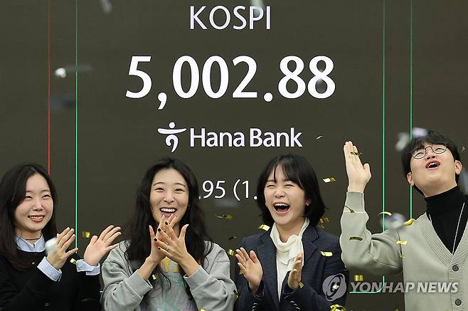 코스피, 5,000선 돌파 순간 (서울=연합뉴스) 이진욱 기자 = 22일 오전 서울 중구 하나은행 딜링룸에서 딜러들이 코스피가 장중 5,000을 넘어서자 기뻐하고 있다. 2026.1.22 cityboy@yna.co.kr