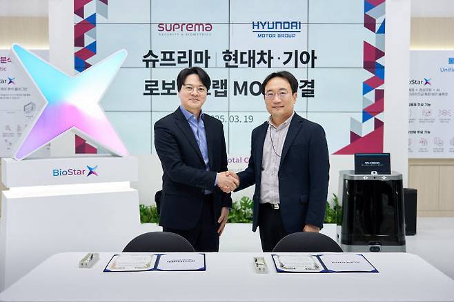 현대차기아 로보틱스랩장 현동진 상무(오른쪽)와 슈프리마 김한철 대표가 작년 3월 로봇 친화 빌딩 구축 확대를 위해 로보틱스 및 AI 기반 토탈 보안 솔루션 구축 사업에 관한 업무협약(MOU)을 맺고 기념 촬영을 하고 있다. (사진=현대차그룹)