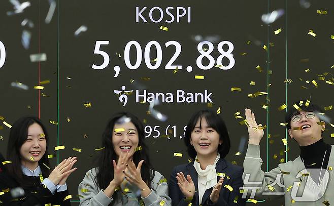 코스피지수가 사상 처음으로 장중 5000을 돌파한 22일 오전 서울 을지로 하나은행 딜링룸에서 직원들이 신기록 달성을 축하하고 있다. 이날 코스피지수는 한때 5019.54까지 상승했다가 0.87% 오른 4952.53에 거래를 마쳤다. 2026.1.22/뉴스1 ⓒ News1 박지혜 기자