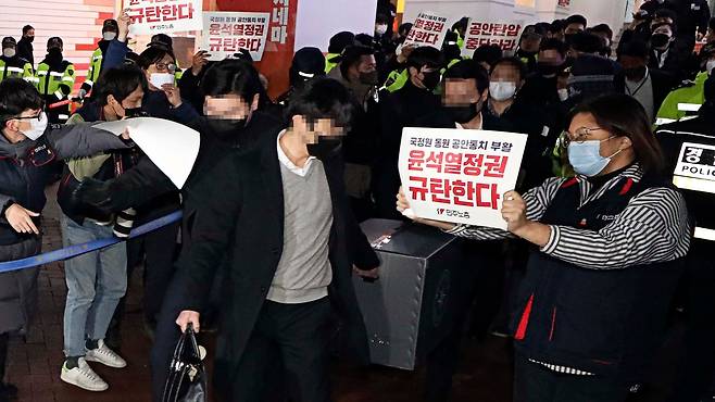 지난 2023년 1월 '간첩단 의혹'과 관련해 서울 정동 민주노총 본부를 압수 수색한 국가정보원 관계자들이 압수한 물품을 들고 나오 있다. /뉴시스