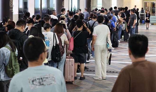 Shoppers wait to enter Lotte Duty Free’s Myeongdong branch in Jung District, central Seoul, on Sept. 23, 2025. [YONHAP]
