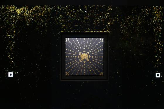 The geumbakjang, or gold-leaf imprinted work, “The Gleam of Ambition ‘Abundance,’” by Kim Gi-ho, which uses a projector to fill the space with layers of shimmering gold particles, at the CookieRun Kingdom’s “Legacy of the Kingdom” art exhibition at the Ara Art Center in Insa-dong in Jongno District, central Seoul. [CHO YONG-JUN]