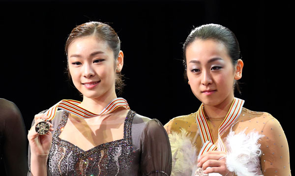 한국의 피겨여왕 김연아가 2013 국제빙상경기연맹(ISU) 세계피겨선수권대회 여자싱글에서 우승을 차지하고 시상대에서 3위 아사다 마오와 사진촬영을 하고 있다. [연합뉴스]