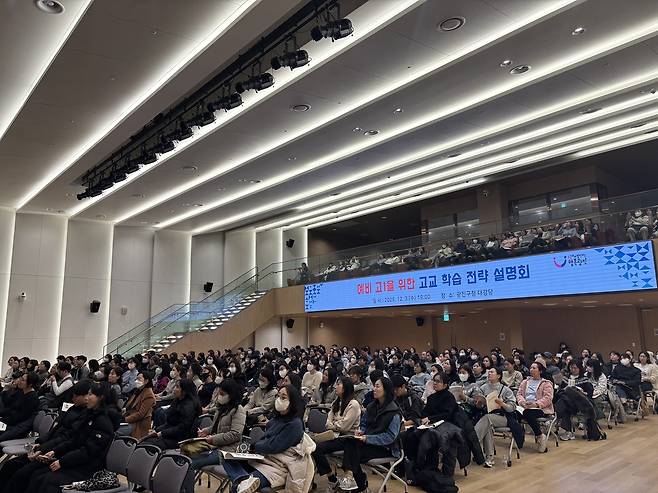 강당에 많은 사람들이 앉아있는 사진이다. 강당 무대 위 스크린에는 ‘개정 고등학교 고교학점제 전략 설명회’라는 텍스트가 보인다.