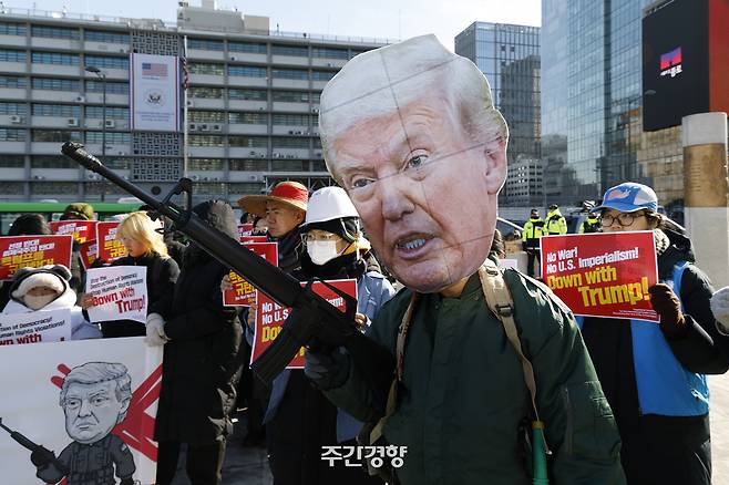 ‘트럼프 1년 규탄 국제민중행동’ 소속 활동가들이 지난 1월 20일 서울 종로구 주한 미국 대사관 앞에서 도널드 트럼프 미국 대통령의 베네수엘라 침공, 관세 전쟁, 팔레스타인에 대한 집단 학살 묵인 등을 비판하는 퍼포먼스를 하고 있다. 문재원 기자
