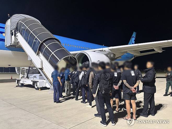 '캄보디아 범죄조직' 한국인 국내 송환 (서울=연합뉴스) 캄보디아에서 스캠(scam·사기), 인질강도 등 범행을 저지른 한국인 범죄 조직원들이 23일 캄보디아 프놈펜국제공항에서 국내로 송환되고 있다. 2026.1.23 [경찰청 제공. 재판매 및 DB 금지] photo@yna.co.kr