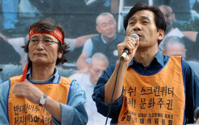 배우 안성기(오른쪽)가 2004년 7월 14일 오후 광화문 정보통신부 앞에서 열린 스크린쿼터 사수를 위한 영화진흥법 개정촉구 및 한미투자 협정 저지를 위한 대국민 보고대회에 참여해 인삿말을 하고 있다. 안성기는 정지영(왼쪽) 감독과 영화인대책위원회 공동위원장을 맡았다. 한국일보 자료사진