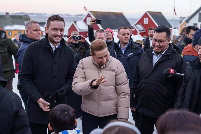 23일(현지시간) 그린란드 수도 누크를 방문한 메테 프레데릭센 덴마크 총리(가운데)와 옌스 프레데릭 닐센 그린란드 총리(왼쪽)가 현지 주민들과 소통하고 있다. AP=연합뉴스