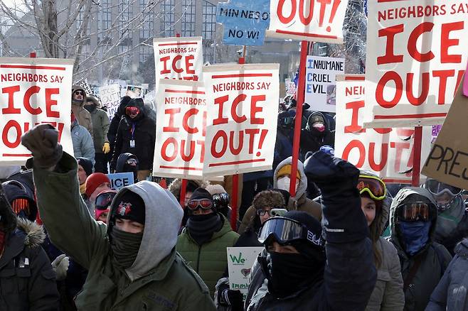 23일(현지시간) 미국 미네소타주 미니애폴리스에서 도널드 트럼프 미 대통령이 이민 단속 요원 수천 명을 도심에 배치한 데 항의하는 총파업이 열린 가운데 시위대가 피켓을 들고 행진하고 있다. 로이터=연합뉴스