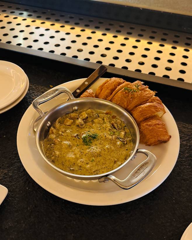 Mushroom cream sea conch with croissant at Dozen Oyster Hannam (Hong Yoo/The Korea Herald)
