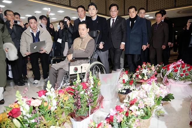 8일째 단식을 이어오던 장동혁 국민의힘 대표가 지난 22일 서울 여의도 국회 로텐더홀에서 단식을 중단한 뒤 병원으로 이동하며 응원차 놓인 꽃다발을 보고 있다. [김재훈 기자]