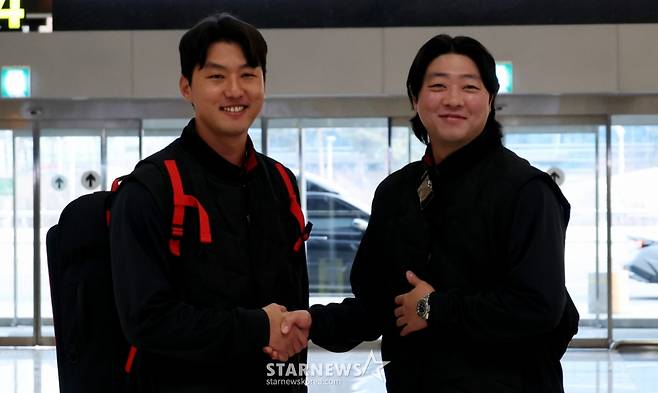 친정으로 돌아온 홍건희(왼쪽)와 한화에서 기아로 FA 이적한 김범수가 23일 김포공항을 통해 일본으로 출국하고 있다.  출국전 기자회견과 포토타임을 갖는 홍건희. /사진=강영조 선임기자