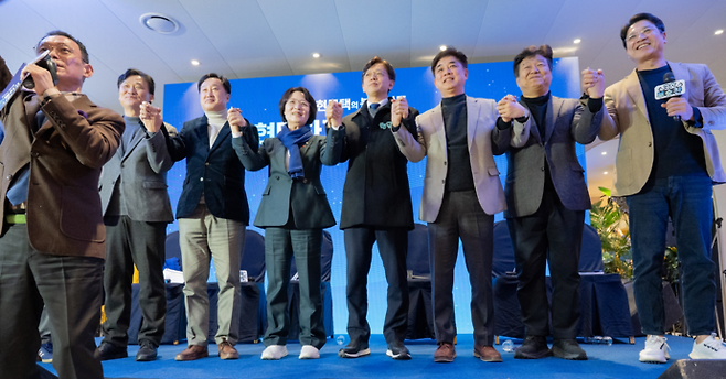 현근택 변호사(가운데)가 지난 24일 용인시 처인구 정그리다 카페에서 연 출판기념회에 참석한 추미애 국회 법사위원장(왼쪽 세 번째) 등과 손을 잡고 사진촬영 하고 있다. 사진=현근택 변호사