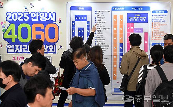 지난해 4월 17일 오후 안양시 만안구 안양아트센터에서 열린 '2025 안양시 4060 일자리박람회'에서 구직자들이 취업정보를 살펴보고 있다. 김경민기자