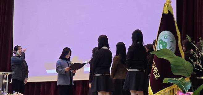 김경미 교장이 각 반 대표들에게 졸업장을 전달하고 있다.