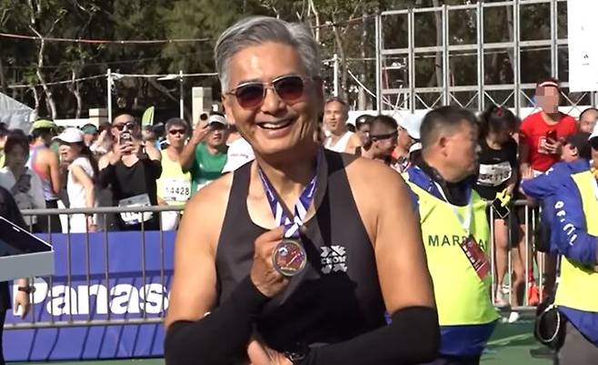 주윤발이 10km를 완주한 뒤 메달을 걸고 환하게 웃고 있다. 사진=VIA 영상 캡처
