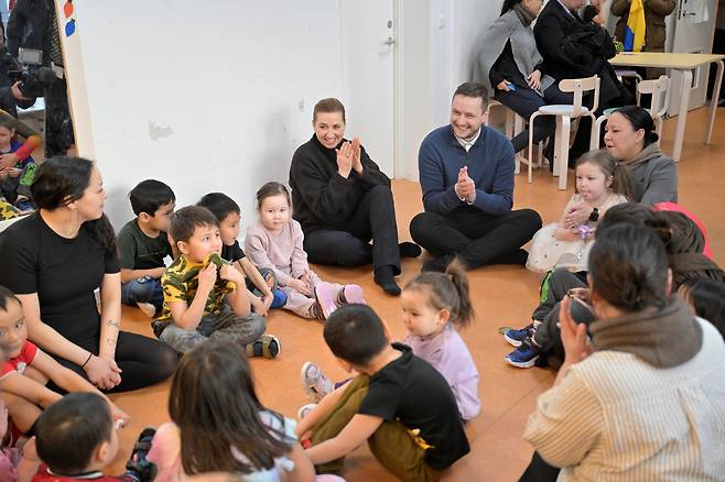 메테 프레데릭센 덴마크 총리(왼쪽)이 지난 24일 그린란드누크를 ‘깜짝 방문’, 옌스페레데리크 닐센 그린란드 정부수반과 함께 누크 시내 한 어린이집을 방문해 어린이들과 함께 시간을 보내고 있다./AP 연합뉴스