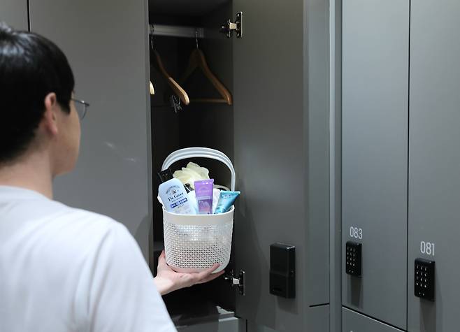 /이마트 제공한 20대 남성이 탈모 케어 제품을 헬스장 탈의실 라커에 집어넣고 있다.