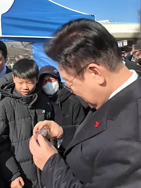 이재명 대통령이 어린이에게 받은 두쫀쿠를 살펴보고 있다. /유튜브