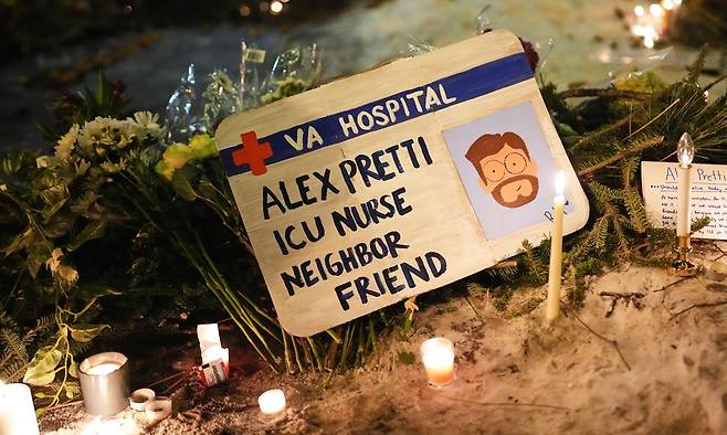 지난 24일 미국 미네소타주 미니애폴리스에서 열린 야간 집회에서 미국 국경 순찰대의 총격으로 사망한 37살 알렉스 프레티의 팻말이 놓여 있다. AP/연합뉴스