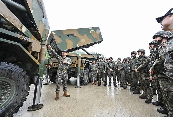 Polish military officers listen to an explanation on the Chunmoo multiple launch rocket system during a demonstration on the K-defense system for soldiers from major overseas defense cooperation countries on May 22, 2025. [YONHAP]