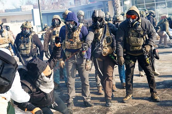 미국 연방 요원들이 24일(현지시간) 미네소타주 미니애폴리스에서 시위대를 향해 후추 스프레이를 분사하고 있다. 연합뉴스