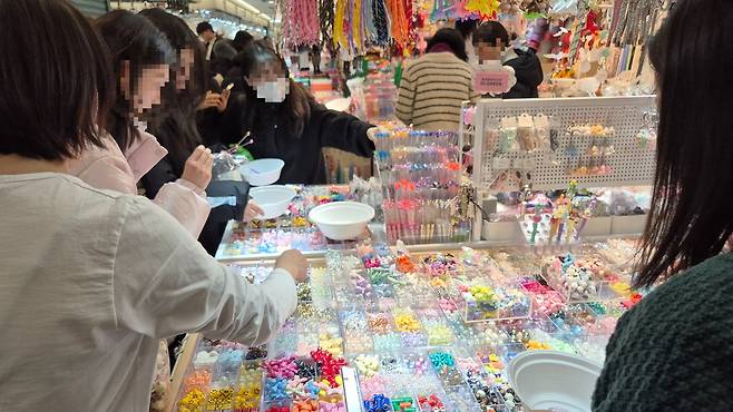 서울 동대문 부자재 상가에서 시민들이 볼꾸·키링 소품을 고르는 모습.  이수민 기자