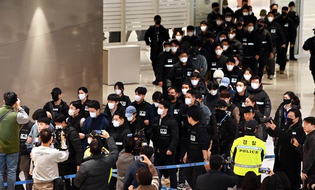 기나긴 송환 행렬. 캄보디아에서 스캠(사기) 및 강력 범죄를 일삼은 혐의로 강제 송환된 한국인 73명이 23일 오전 대한항공 KE9690편 전세기를 타고 인천 중구 인천국제공항에 도착, 경찰에 압송되고 있다. 박윤슬 기자
