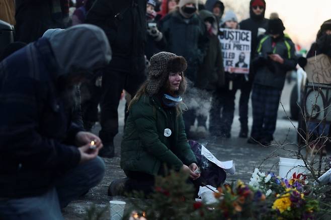 24일(현지시간) 미국 미네소타주 미니애폴리스에서 사람들이 알렉스 프레티(Alex Pretti)의 사망 현장에 마련된 임시 추모 공간 주변에 모여 있다. 알렉스 프레티는 연방 요원들이 그를 제압하려 시도하던 중 쏜 총에 맞아 숨진 것으로 확인되었다. 2026.1.25. 로이터 연합뉴스